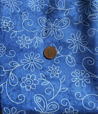 Blått tyg med blommor och fjärilar