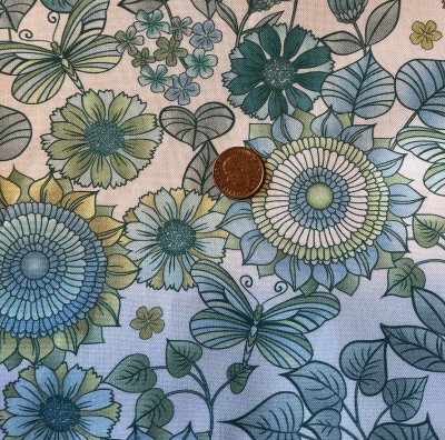 Ljust tyg med blommor och blad i grönt och blått