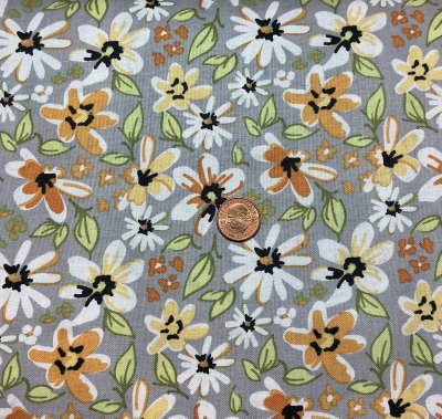 Grått tyg med blommor och blad i orange,svart och grönt